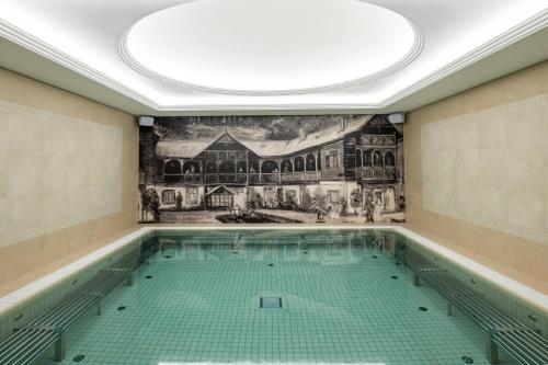 an indoor swimming pool with a mural on the wall at Kúpele Brusno - Kúpeľný hotel Poľana in Brusno