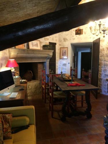 une salle à manger avec une table et une cheminée dans l'établissement La Sanglière, à Ampus