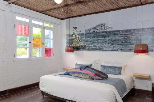 a bedroom with a bed and a painting on the wall at Placita Vieja Hotel Boutique Spa in Santa Marta