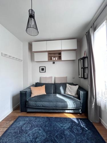 - un canapé bleu dans le salon doté d'un tapis bleu dans l'établissement Charmante studette Paris 5e, à Paris