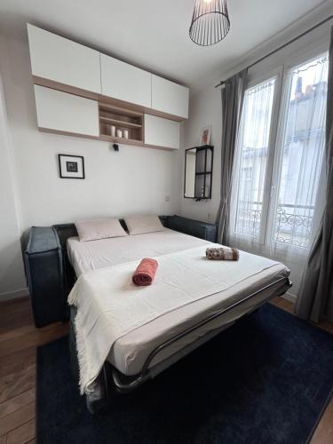 une chambre avec un grand lit avec des serviettes dessus dans l'établissement Charmante studette Paris 5e, à Paris