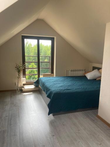 a bedroom with a bed and a large window at "Ukryty w tujach" dom na wyłączność 6-14 osób in Międzyrzec Podlaski