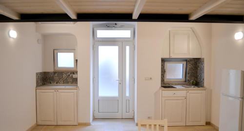a kitchen with white cabinets and a door with a window at Dimora Manzoni in Noci