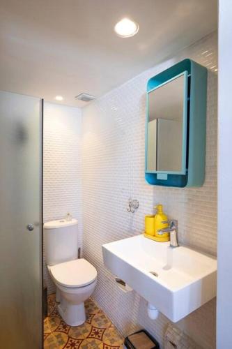 a bathroom with a sink and a toilet and a mirror at Cozy Tiny House in Neve Tzedek, 3m walk to Beach! in Tel Aviv