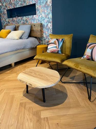 Cette chambre comprend un lit, deux chaises et une table. dans l'établissement La Bohème, Maison de bourg, à Chaudes-Aigues