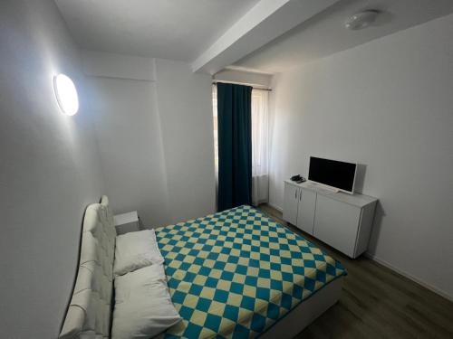 a small bedroom with a bed and a television at AlyStar apartament in Mamaia Sat/Năvodari