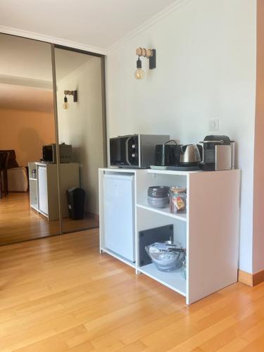 une cuisine avec une étagère blanche et de la nourriture. dans l'établissement Logement près de Disneyland Paris, à Pontault-Combault