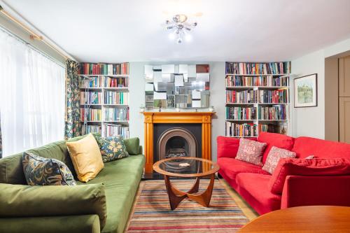 a living room with a red couch and a fireplace at Ultra Central London, Garden, King Bed in London