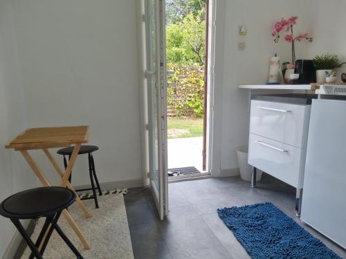 une cuisine avec une table et une porte donnant sur une cour dans l'établissement Studio indépendant et Jardin 600m2 Terrasse, à Carbon-Blanc