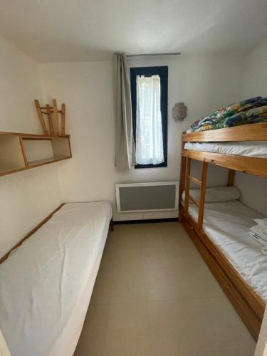 une petite chambre avec deux lits superposés et une fenêtre dans l'établissement Appartement pieds des pistes, à Réallon