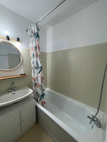 une salle de bain avec un lavabo, une baignoire et un miroir dans l'établissement Appartement pieds des pistes, à Réallon