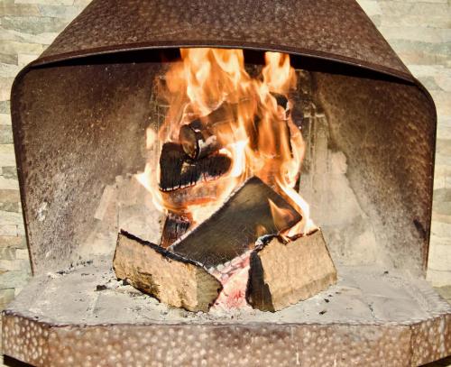 a fire burns inside of a brick fireplace at Loft de montaña Los Guayacanes in San José de Maipo