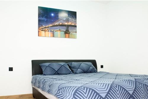 a bedroom with a bed with a painting on the wall at Vikendica Oaza in Babići