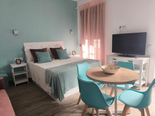 a bedroom with a bed and a table and chairs at Casa Cervera in San Fernando