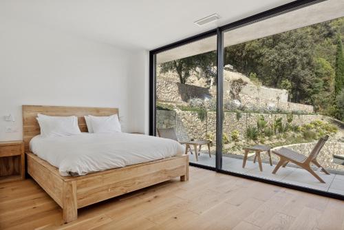 une chambre avec un lit et une grande fenêtre dans l'établissement Villa Y, à Vence