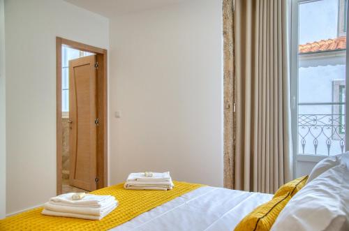 a bedroom with a bed with towels on it at Castro's Inn Monção in Monção