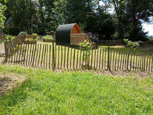 a fence with a spare tire in a garden at Le Rocher du Samoyède in Dirinon