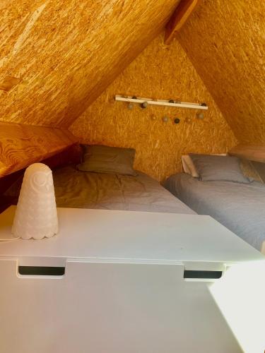 two beds in a room with a roof at Saules et Têtards in Frasnes-lez-Anvaing