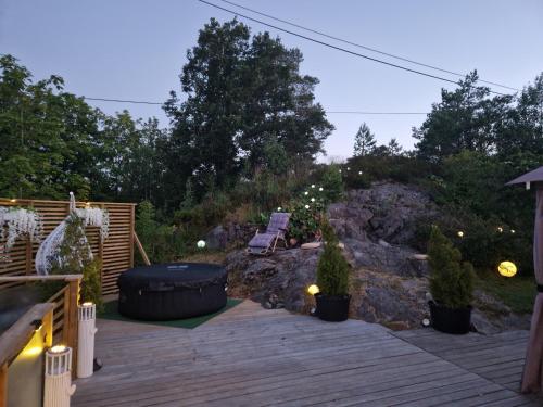 a backyard deck with a bench and trees and lights at soul & spa holiday home in Arendal