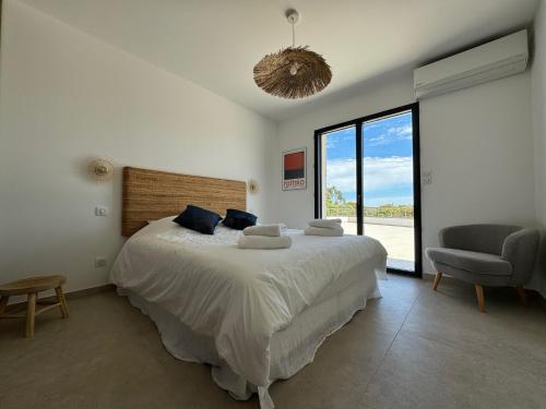 une chambre avec un grand lit et une chaise dans l'établissement Villa Bavella, à Zonza