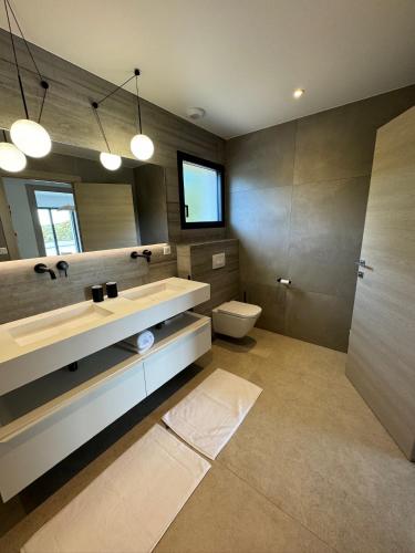 une salle de bain avec un lavabo, des toilettes et un miroir dans l'établissement Villa Bavella, à Zonza