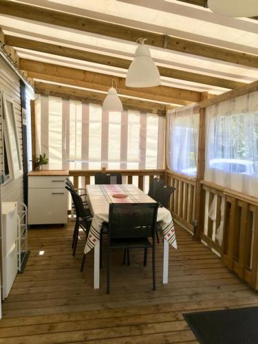 une salle à manger avec une table et quelques chaises dans l'établissement Mobilhome de 45 m2 au camping La Réserve, à Gastes