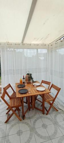 - une table et des chaises en bois dans l'établissement Maison atypique O'ZEN à 5 min de La Rochelle, à Saint-Xandre