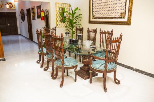 a dining room with a glass table and chairs at Diplomat Fort Boutique Hotel in Karachi