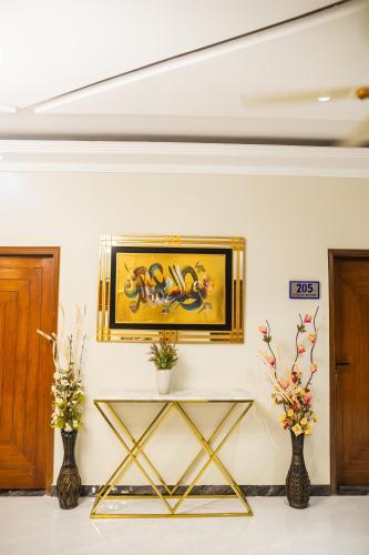a room with two vases and a painting on the wall at Diplomat Fort Boutique Hotel in Karachi
