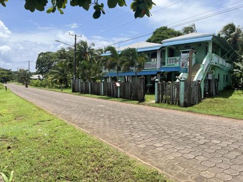 a blue house on the side of a road at Hospedaje Rosa Del Mar & Sweets Cafe in Big Corn Island