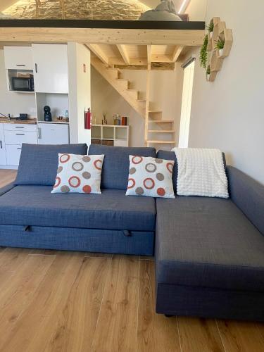 a blue couch with pillows in a living room at Turismo e Alojamento dos Lagos do Sabor - Piscina & SPA in Meirinhos