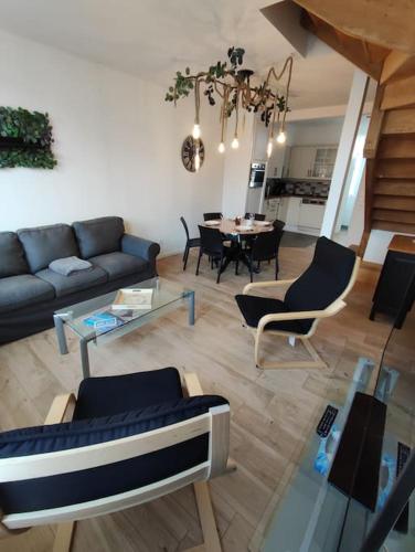 a living room with a couch and a table at So Chic in Forges-les-Eaux