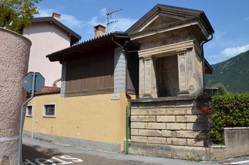 a small yellow building on the side of a street at Residenza Al Capitello in Ceniga