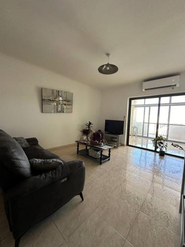 a living room with a couch and a tv at Cozy Room in Gzira - Close to Beachfront in Il-Gżira