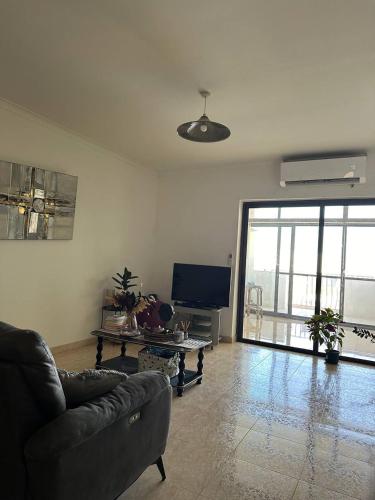 a living room with a couch and a tv at Cozy Room in Gzira - Close to Beachfront in Il-Gżira
