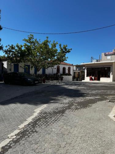 an empty street with a tree and a building at Evdokiahouse in Áno Kalésia