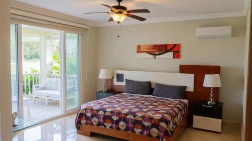 a bedroom with a bed and a ceiling fan at Hispaniola Beach Condo 9a2oceanviewbeachpool in Sosúa