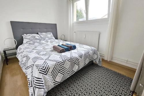 a bedroom with a bed with a black and white comforter at Appartement F2 Villeparisis in Villeparisis