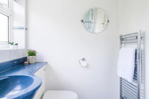a bathroom with a blue sink and a toilet at Leicester Oadby 4 bed home, 8 guests, park 5 cars in Oadby