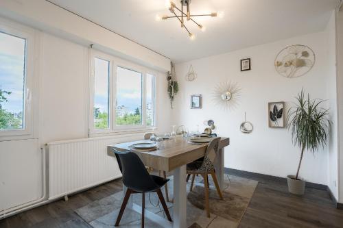 une salle à manger avec une table, des chaises et des fenêtres dans l'établissement Le Stanny - 2 lits - 4 pers' - parking - Streaming, à Metz