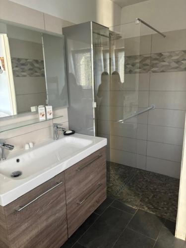 a bathroom with a sink and a glass shower at Chez Katty in Régusse