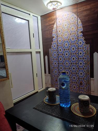 a bottle of water sitting on a table with two cups at Alone Studio in Casablanca