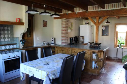 - une cuisine avec une table, des chaises et une cuisinière dans l'établissement GITE Le Bol d Air, à Mentque-Nortbécourt