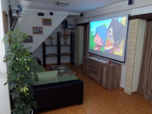 a living room with a flat screen tv and a couch at Casa Rural Majaceite in El Bosque