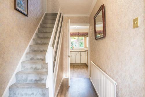 a staircase in a home with a mirror on the wall at Leicester Oadby 4 bed home, 8 guests, park 5 cars in Oadby