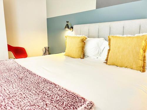 a bedroom with a large white bed with yellow pillows at The Traveler's Getaway in San Diego