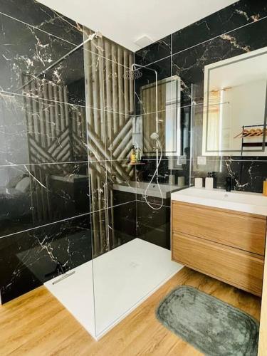 une salle de bain avec une douche en verre et un lavabo dans l'établissement Le Repos du Pilat proche à 10 min Saint Etienne, à Saint Etienne