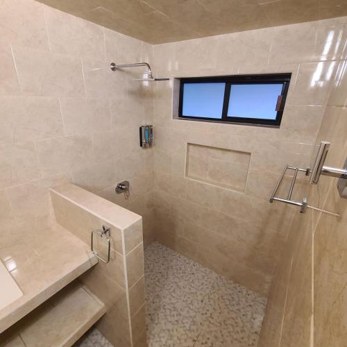a bathroom with a shower and a sink and a window at Casa Cactus in San Sebastian Xolalpa