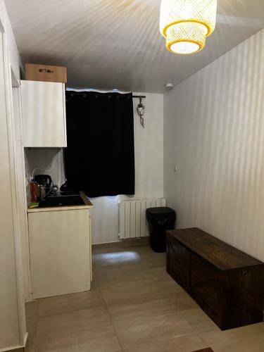 une petite cuisine avec une fenêtre noire dans une pièce dans l'établissement Beau-voisin 1, à Rouen