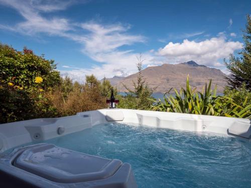 a hot tub with a view of a mountain at Papillon, a Relax it's Done luxury holiday home in Queenstown